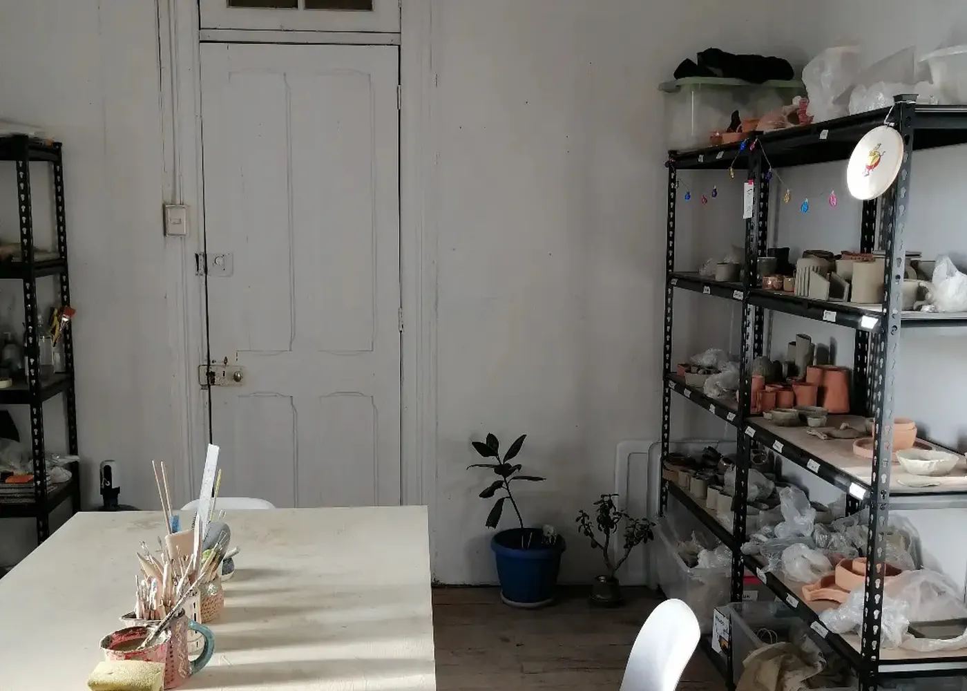 Mesa de trabajo, herramientas y estanterías del estudio de Conocerámica